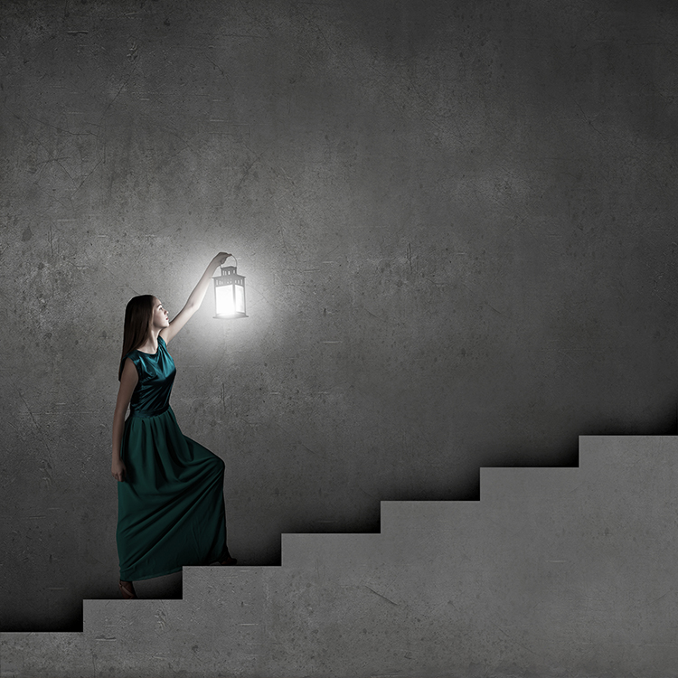 Young woman with lantern walking in darkness